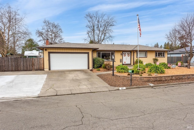 single story home featuring a garage, driveway, and fence