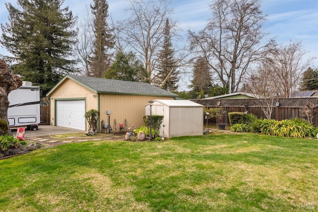 view of yard featuring an outbuilding, fence, and a detached garage