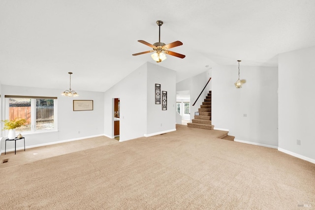 unfurnished living room featuring lofted ceiling, carpet flooring, and ceiling fan with notable chandelier