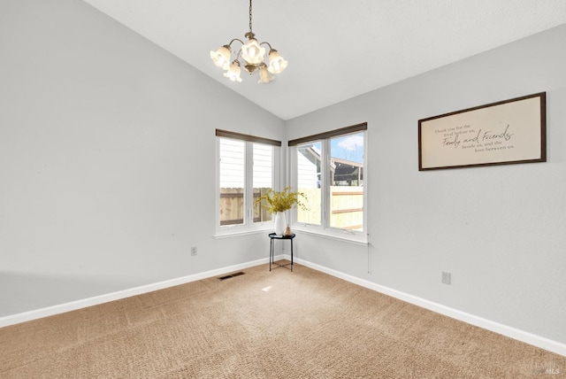 carpeted spare room with lofted ceiling and a chandelier