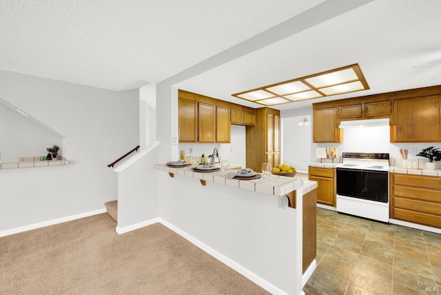 kitchen featuring tile countertops, kitchen peninsula, a textured ceiling, and white range with electric stovetop