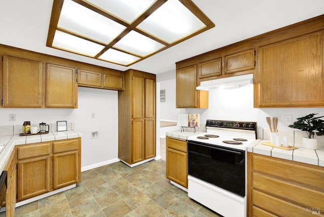 kitchen with dishwasher, tile counters, and electric range