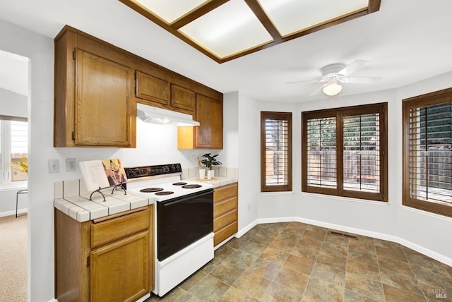 kitchen with tile counters, ceiling fan, and white range with electric stovetop