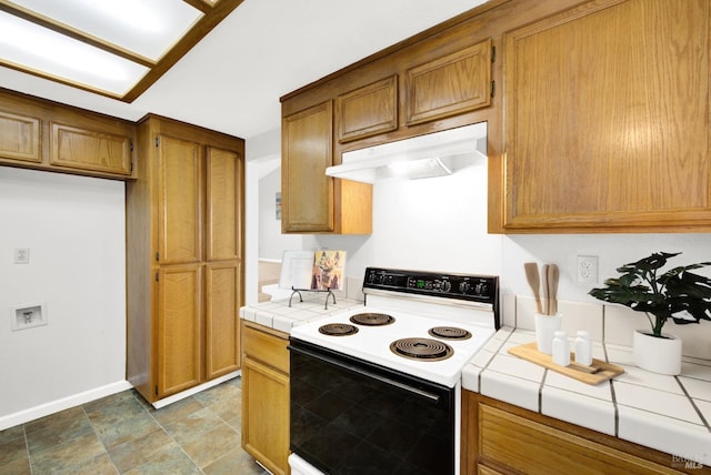 kitchen featuring electric range oven and tile counters