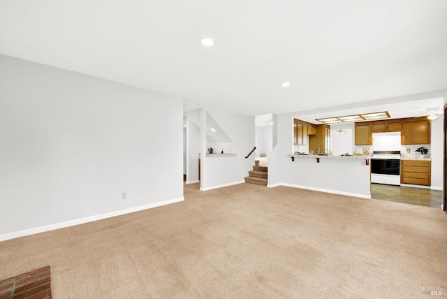 unfurnished living room with light carpet and a textured ceiling