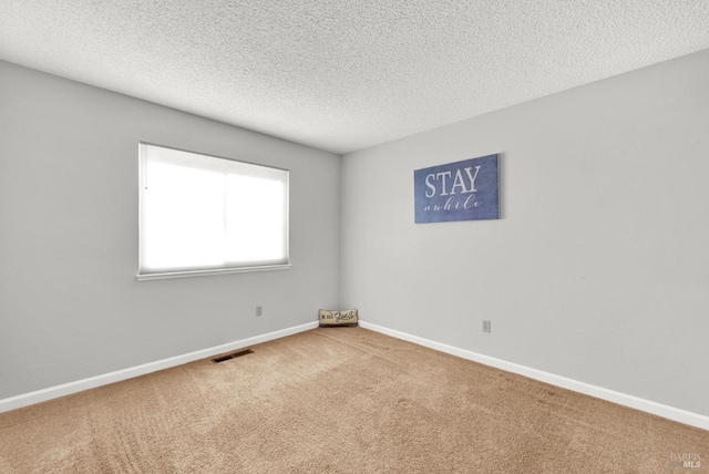 carpeted spare room featuring a textured ceiling