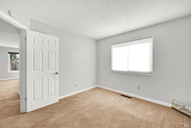 unfurnished room with carpet floors and a textured ceiling