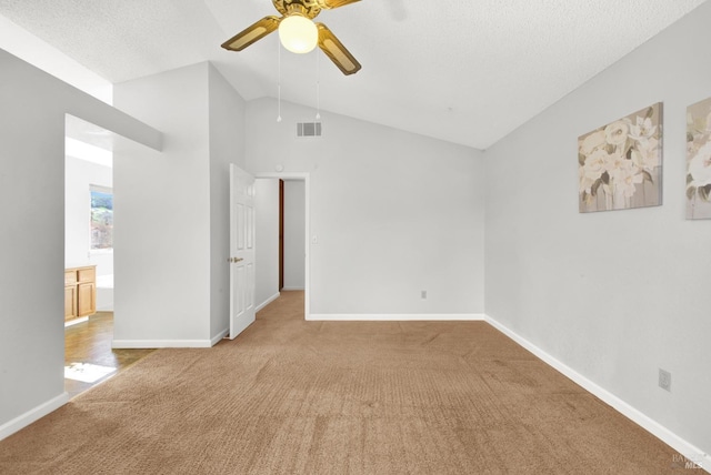 interior space featuring ceiling fan, carpet flooring, vaulted ceiling, and a textured ceiling