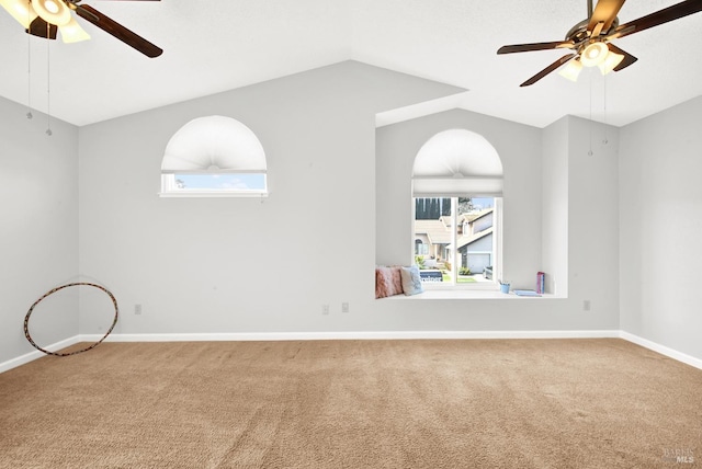 empty room with vaulted ceiling, carpet floors, and ceiling fan