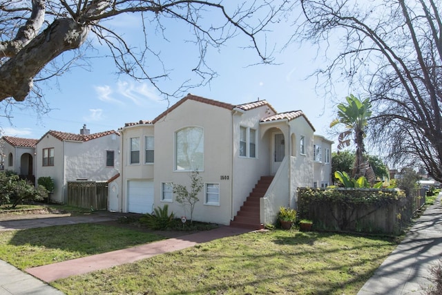 mediterranean / spanish house with a garage and a front lawn