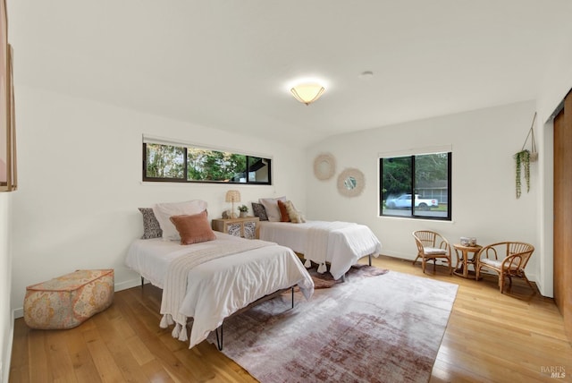 bedroom with baseboards and light wood finished floors