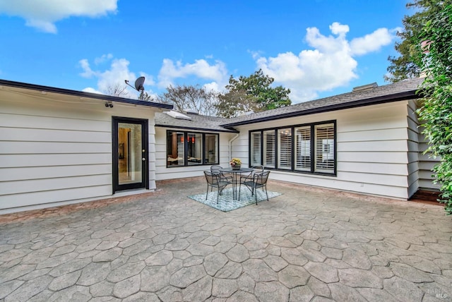 back of property featuring a patio area and outdoor dining space