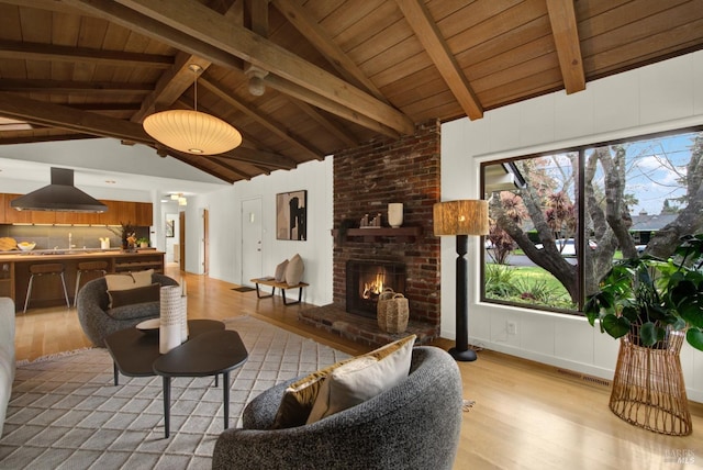 living area with visible vents, light wood finished floors, wood ceiling, and lofted ceiling with beams