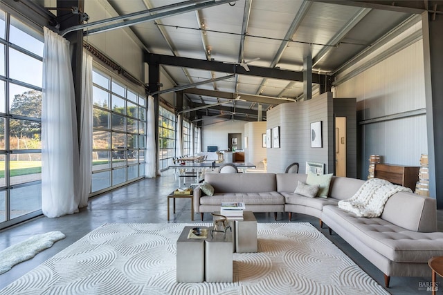 living room with concrete floors and high vaulted ceiling