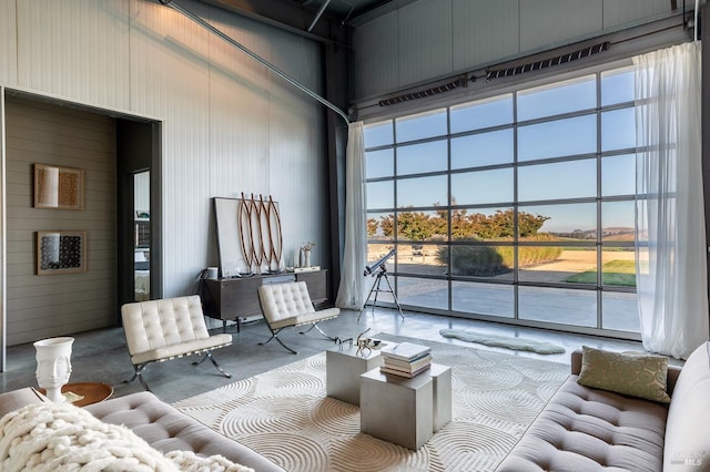 living room featuring a towering ceiling and concrete floors