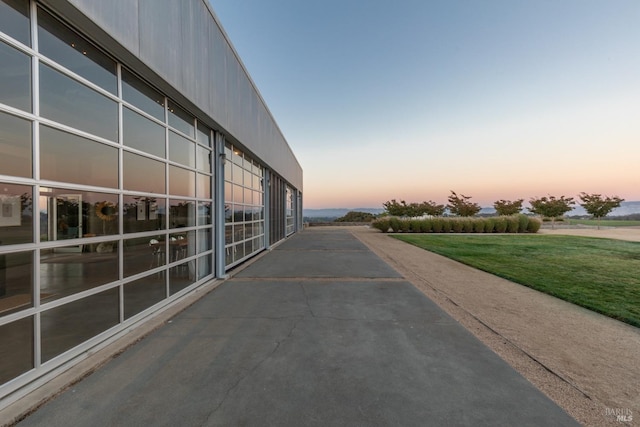 property exterior at dusk featuring a lawn