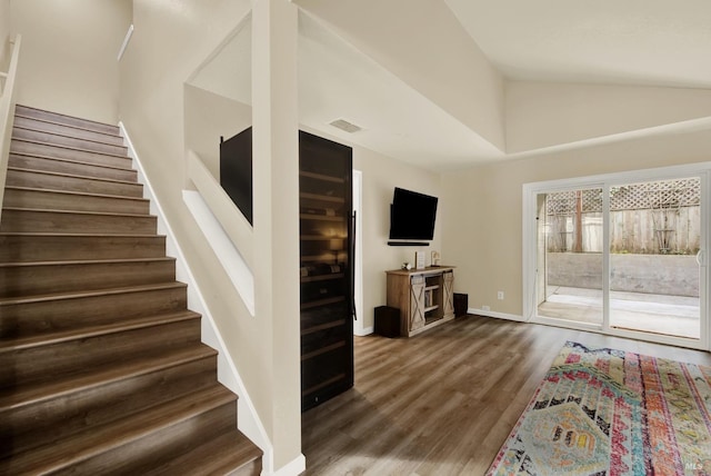 stairway with lofted ceiling and wood-type flooring