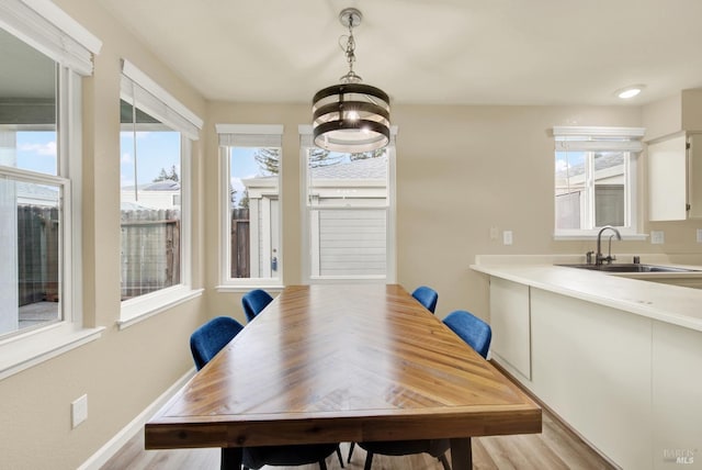 dining room with plenty of natural light, sink, and light wood-type flooring