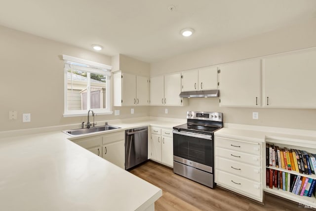 kitchen featuring white cabinetry, kitchen peninsula, stainless steel appliances, sink, and wood-type flooring