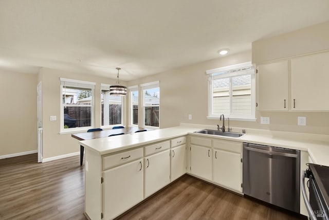 kitchen featuring range, dishwasher, decorative light fixtures, sink, and kitchen peninsula