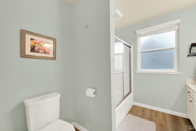 full bathroom featuring toilet, vanity, shower / bath combination with glass door, and wood-type flooring