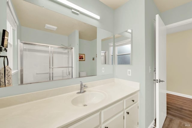 bathroom with vanity, an enclosed shower, toilet, and hardwood / wood-style floors