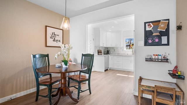 dining space featuring baseboards and light wood finished floors