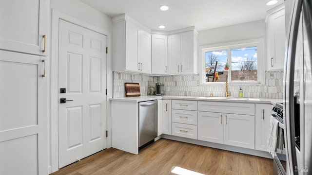 kitchen with white cabinetry, appliances with stainless steel finishes, light countertops, and a sink