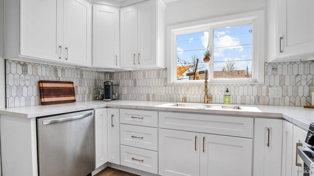 kitchen with a sink, tasteful backsplash, white cabinets, and stainless steel dishwasher