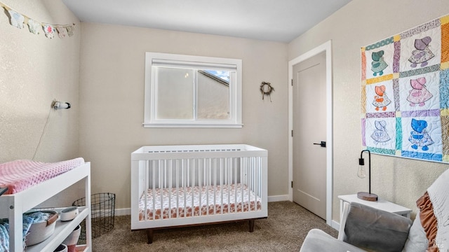 carpeted bedroom featuring a crib and baseboards