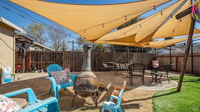 view of patio with a fenced backyard and a fire pit