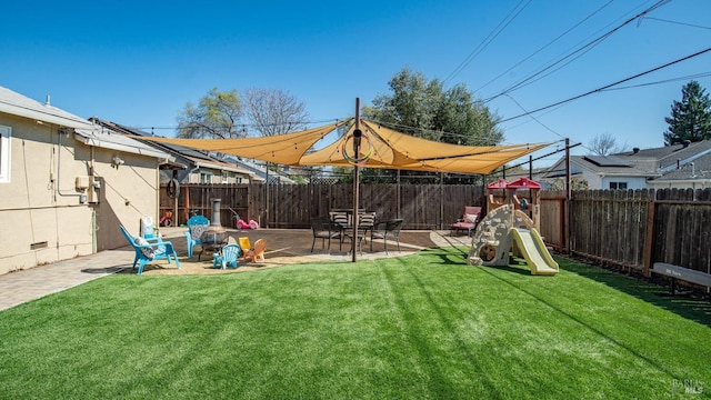 view of yard with a patio, a playground, and a fenced backyard