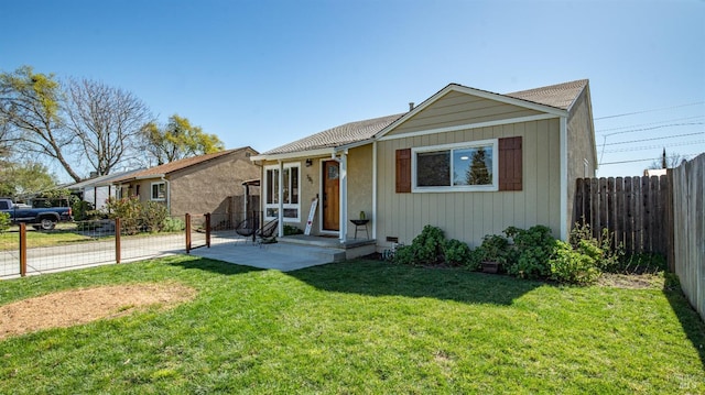 view of front of home featuring fence and a front lawn