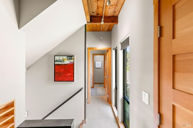 corridor with light tile patterned floors, wood ceiling, and beamed ceiling