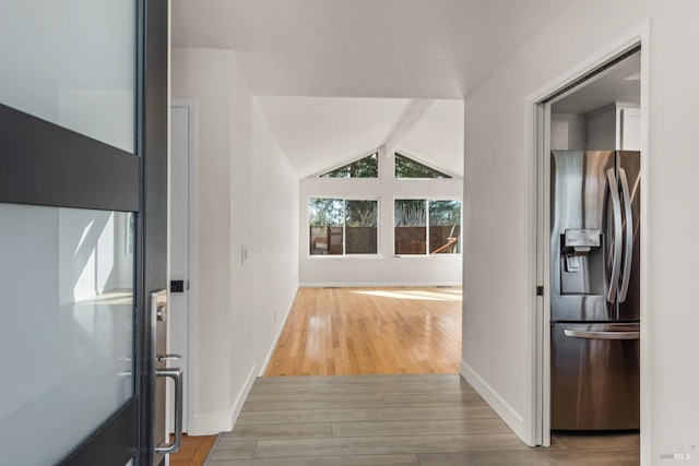 corridor with vaulted ceiling with beams, baseboards, and wood finished floors