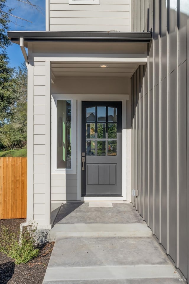 doorway to property featuring fence