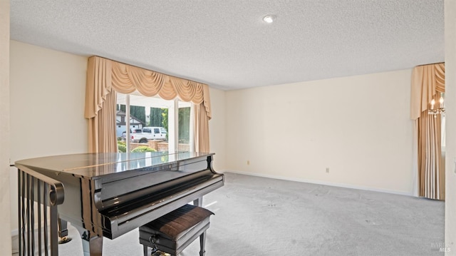 living area featuring baseboards, a textured ceiling, and light colored carpet