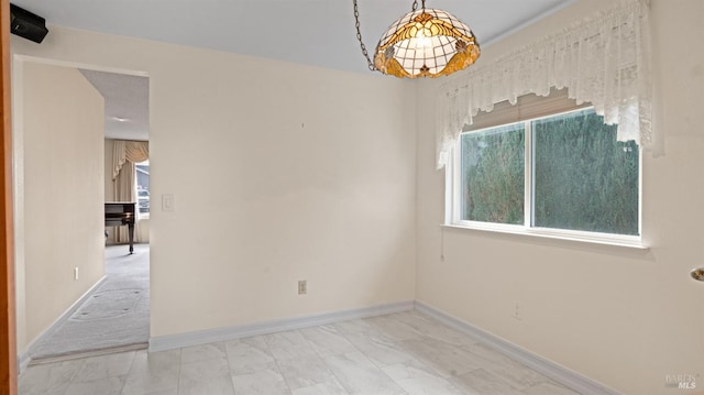 spare room with marble finish floor and baseboards