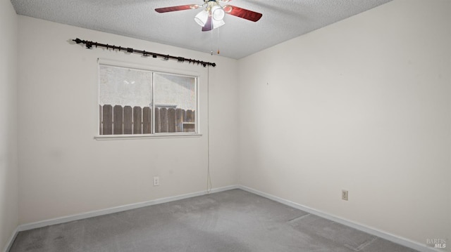spare room featuring carpet floors, ceiling fan, baseboards, and a textured ceiling