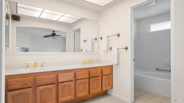 full bathroom featuring double vanity, a ceiling fan, and a sink