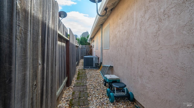 view of property exterior featuring central air condition unit, fence, and stucco siding