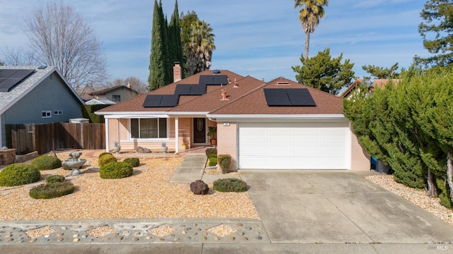 ranch-style home featuring a chimney, a shingled roof, concrete driveway, fence, and a garage