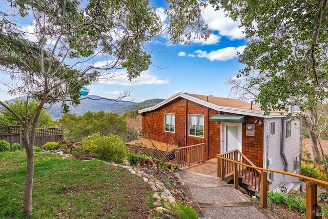 ranch-style house featuring a mountain view and a front lawn