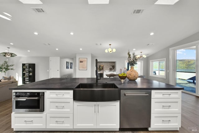 kitchen with oven, sink, hardwood / wood-style floors, and white cabinets