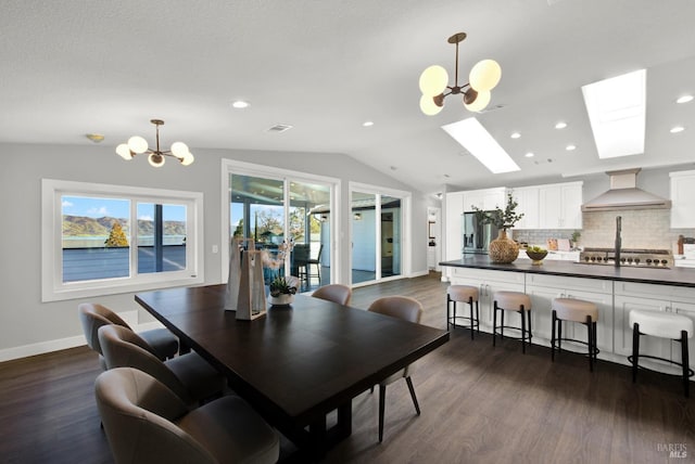 dining space with dark hardwood / wood-style flooring, lofted ceiling with skylight, and a chandelier