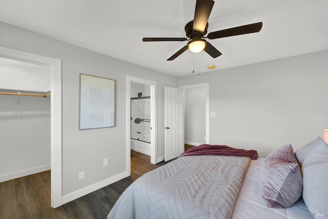 bedroom with dark wood-type flooring, ceiling fan, a spacious closet, and a closet