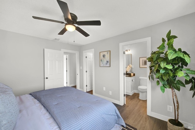 bedroom featuring ceiling fan, ensuite bathroom, and dark hardwood / wood-style flooring