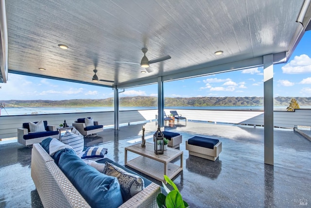 view of patio with a water and mountain view, outdoor lounge area, and ceiling fan