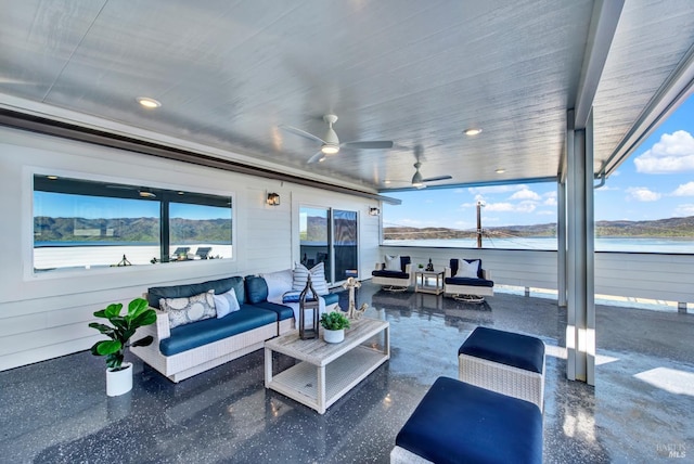 view of patio featuring ceiling fan, an outdoor living space, and a water and mountain view