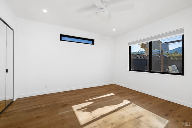 empty room with hardwood / wood-style flooring and ceiling fan